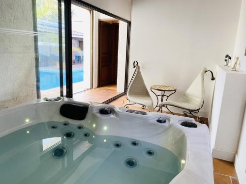 a white bath tub in a room with a pool at Le Patio Bleu in La Crau