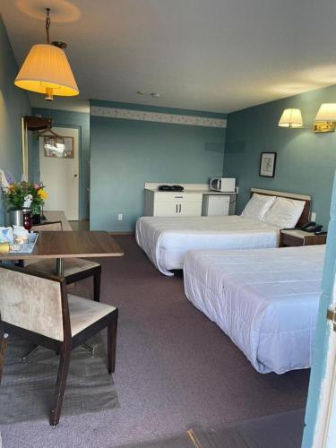 a hotel room with two beds and a table at Earlton Motel in Earlton