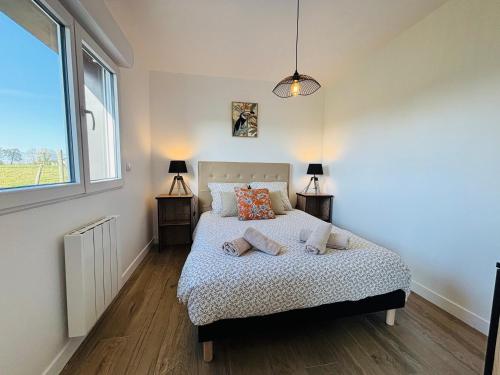 a bedroom with a bed with pillows and a window at jolie chalet Normand - classée 3 étoiles in Beuzeville