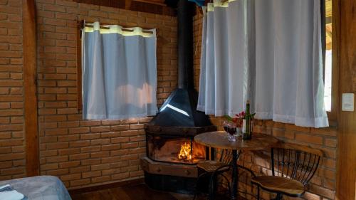 a brick wall with a wood stove in a room at Chalés Das Estrelas in Visconde De Maua