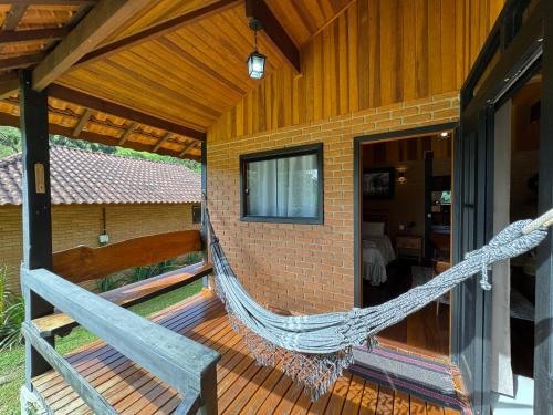 a hammock on the porch of a house at Chalés Das Estrelas in Visconde De Maua