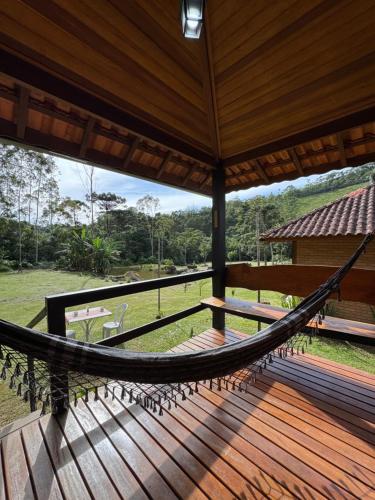 a hammock on the porch of a house at Chalés Das Estrelas in Visconde De Maua