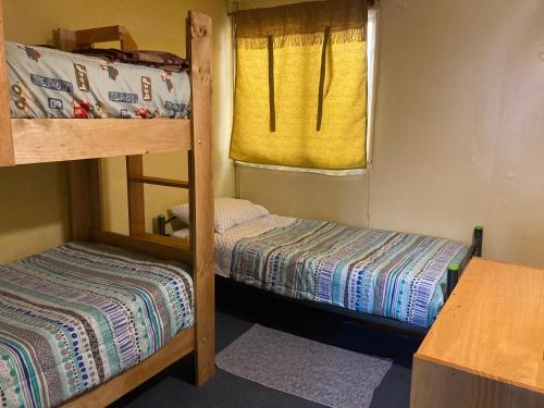 a small room with two bunk beds and a window at Casa Cabaña Oro Rayado Puerto Varas in Puerto Varas