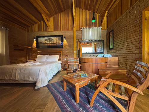 a bedroom with a bed and a brick wall at Chalés Das Estrelas in Visconde De Maua