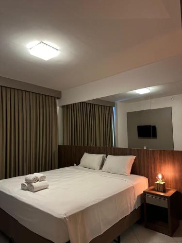 a bedroom with a large bed with towels on it at Barretos Park Hotel, Parque do Peão de Barretos in Barretos