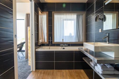a bathroom with a tub and a sink at Hostellerie de la Pointe Saint-Mathieu - SPA & Restaurant in Plougonvelin