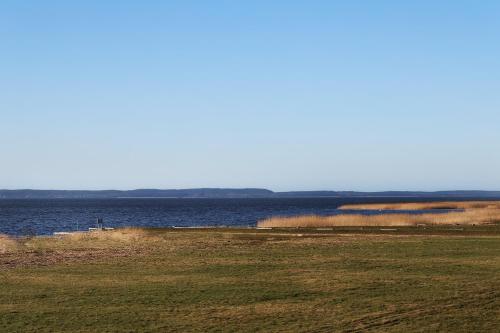 a large body of water with a field and a body of water at NORA Svencele in Svenele