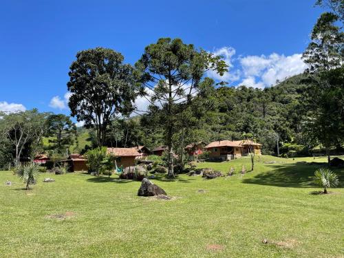 a field of grass with houses in the background at Chalés Das Estrelas in Visconde De Maua