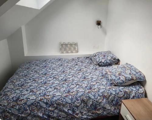- une chambre avec un lit doté d'une couverture bleue et d'oreillers dans l'établissement Petite Maison 3 chambres Lamballe-Armor, à Lamballe Armor