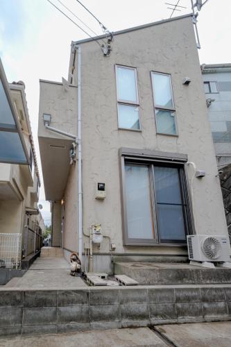 a dog sitting in front of a building at Hachioji Akatsuki Guest House in Hachioji