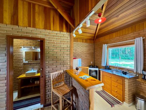 a kitchen with a table and a counter in a room at Chalés Das Estrelas in Visconde De Maua