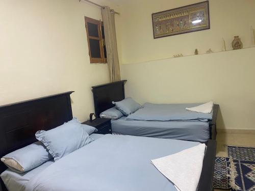 a room with two beds and a window at Pyramids Lounge Guest House in Cairo