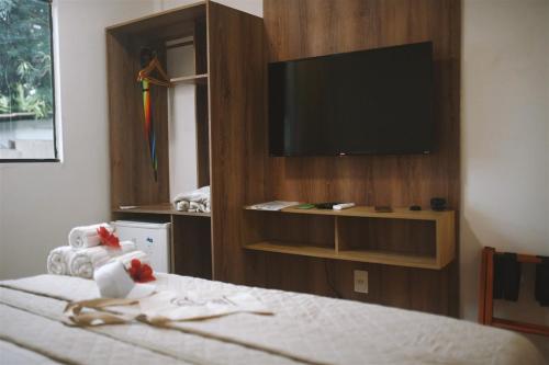 a hotel room with a tv and a bed at Casa do Pedrinho Noronha in Fernando de Noronha