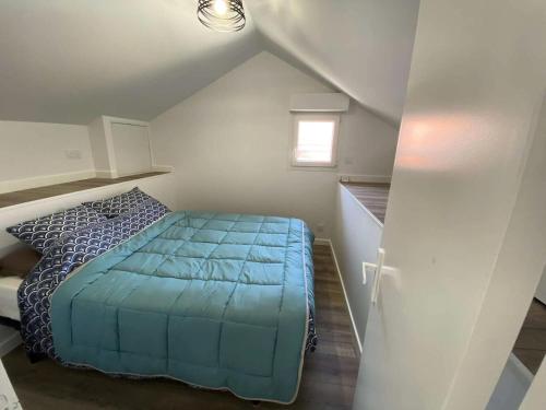 - une chambre mansardée avec un lit bleu dans l'établissement Résidence 103-soulac Sur Mer - 103 - Charmante Soulacaise proche des plages MAE-8881, à Soulac-sur-Mer