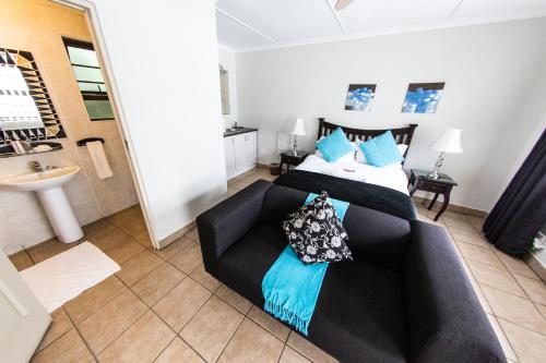 a living room with a couch and a bed at Fish Eagle Manor in East London