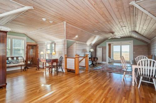 a living room with a wooden ceiling and a table and chairs at Lily's Pad in Oak Island