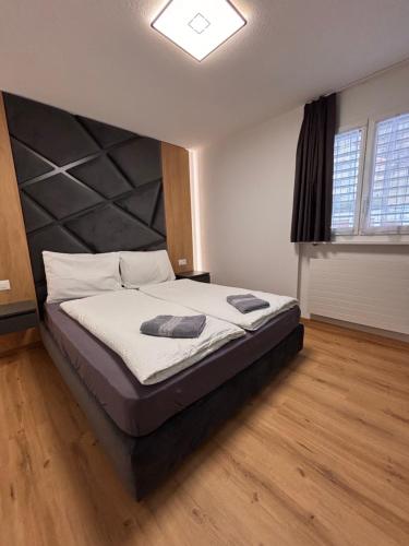 a bedroom with a large bed with a large headboard at Luxuse Ferienwohnung Flüe 11 in Leukerbad