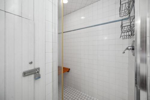 a bathroom with a shower with white tiles at Lily's Pad in Oak Island