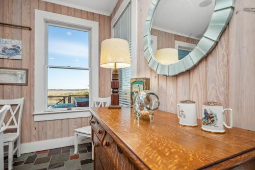 a kitchen with a counter with a mirror and a table at Lily's Pad in Oak Island