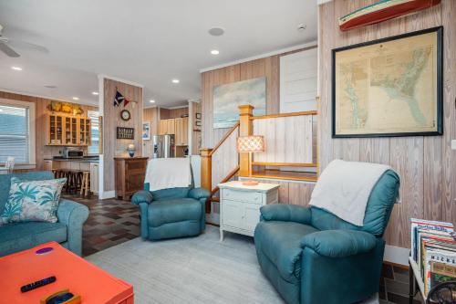 a living room with two blue chairs and a table at Lily's Pad in Oak Island