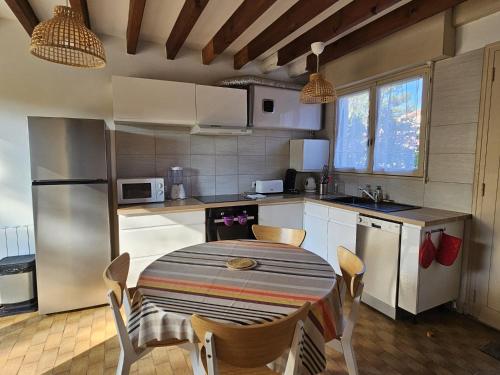 - une cuisine avec une table et des chaises dans l'établissement Capbreton - Villa Patio - Plage - Famile, à Capbreton