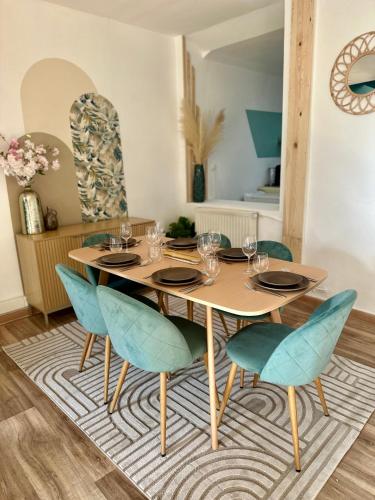 une table à manger avec des chaises bleues sur un tapis dans l'établissement La belle échappée, maison chic près de lille & Parc Barbieux, à Roubaix