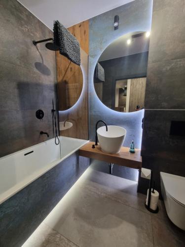 a bathroom with a sink and a mirror at Parkowa Premium Apartment in Gdynia