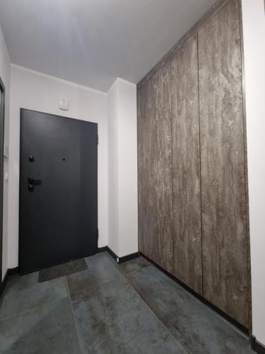a hallway with a black door and a wall at Parkowa Premium Apartment in Gdynia