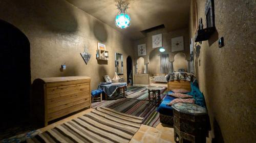 a living room with a couch and a table at Riad Amar in Merzouga
