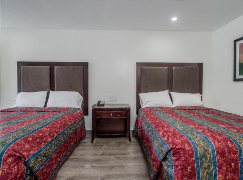 two beds sitting next to each other in a room at Alameda Motel San Jose in San Jose