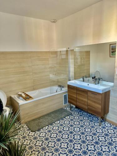 une salle de bain avec une baignoire et un lavabo dans l'établissement La belle échappée, maison chic près de lille & Parc Barbieux, à Roubaix
