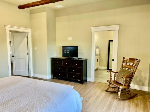 a bedroom with a bed and a tv and a chair at NEW Stunning Views & Lake Access Villa in Granbury