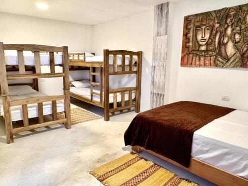 a bedroom with two bunk beds and a bed with a painting at Waikiki beach Hotel Boutique in Dibulla
