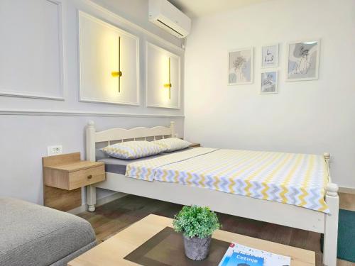 a bedroom with two beds and a table in it at Apartments Gruda in Cetinje