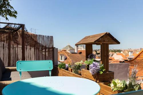 a table and a chair on a balcony with a gazebo at Casa das Andorinhas in Lisbon