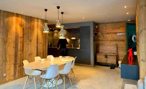 une salle à manger avec une table et des chaises blanches dans l'établissement Chamonix Bellevue, à Chamonix-Mont-Blanc