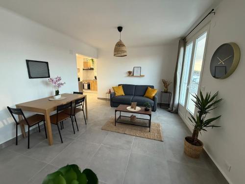 un salon avec un canapé bleu et une table dans l'établissement Superbe Luxury F3 Proche Paris & Disneyland, à Neuilly-sur-Marne