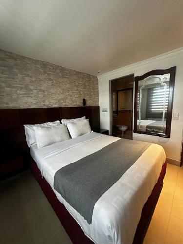 a bedroom with a large bed in a hotel room at Lavid Hotel Palacio Real in Bogotá