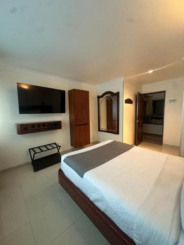 a bedroom with a large bed and a flat screen tv at Lavid Hotel Palacio Real in Bogotá