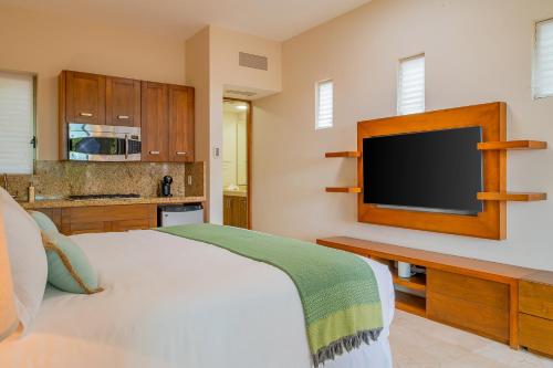 a bedroom with a bed and a flat screen tv at Spacious 5 Bd Villa Fully Staffed w Chauffeur in Puerto Los Cabos! in San José del Cabo