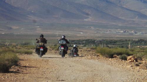 a group of people riding motorcycles on a dirt road at DAR AL QANASS IMANE in Midelt