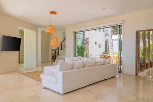 a white couch in a living room with a tv at Spacious 5 Bd Villa Fully Staffed w Chauffeur in Puerto Los Cabos! in San José del Cabo