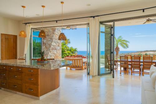 a kitchen and dining room with a view of the ocean at Spacious 5 Bd Villa Fully Staffed w Chauffeur in Puerto Los Cabos! in San José del Cabo