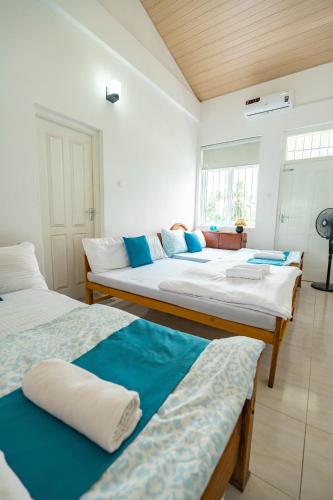 a room with two beds with blue and white at Spacious Eco House with Garden and Scenic Paddy View Colombo in Malabe