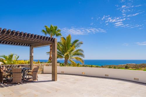 a patio with a table and chairs and the ocean at Spacious 5 Bd Villa Fully Staffed w Chauffeur in Puerto Los Cabos! in San José del Cabo
