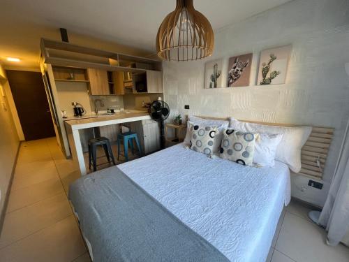 Un dormitorio con una cama grande y una cocina. en Lindo departamento tipo Loft en Ñuñoa, en Santiago