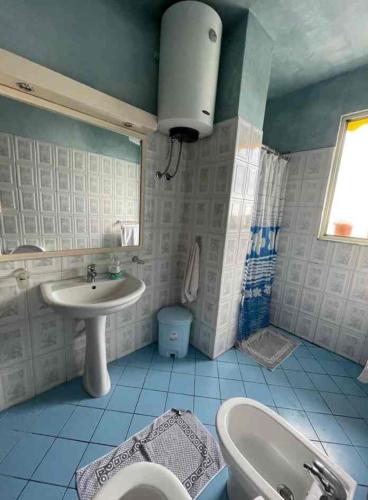a blue and white bathroom with a sink and a toilet at Vistamar Apartment in Golem