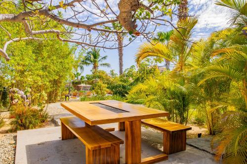 a wooden picnic table and benches in a garden at Spacious 5 Bd Villa Fully Staffed w Chauffeur in Puerto Los Cabos! in San José del Cabo