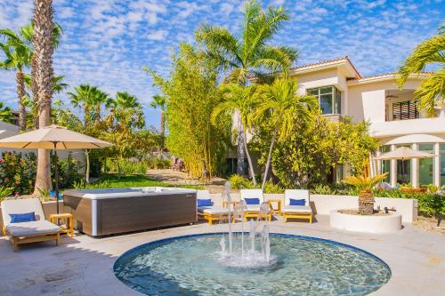 a fountain in a courtyard with chairs and a house at Spacious 5 Bd Villa Fully Staffed w Chauffeur in Puerto Los Cabos! in San José del Cabo