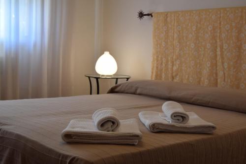 a bedroom with a bed with towels and a lamp at Casa Vacanza e per lavoro Elena e Carla in Spinea